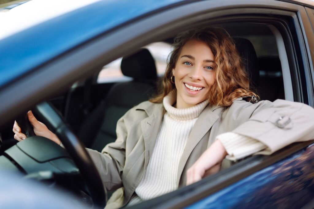 Young woman driving a car in the city. Car sharing, rental service or taxi app.